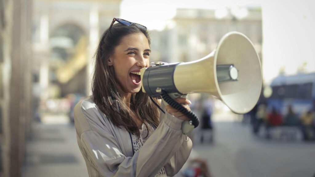 Donna con megafono che comunica un messaggio, simbolo di storytelling del brand