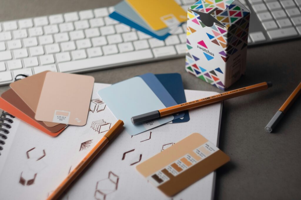 Campioni di colore e strumenti grafici su scrivania per la progettazione di un brand design professionale.