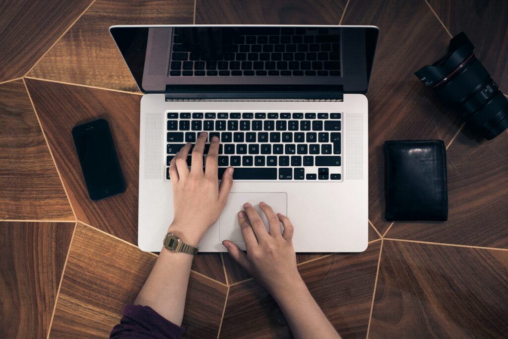 Mani al lavoro su un sito web professionale con laptop e strumenti creativi