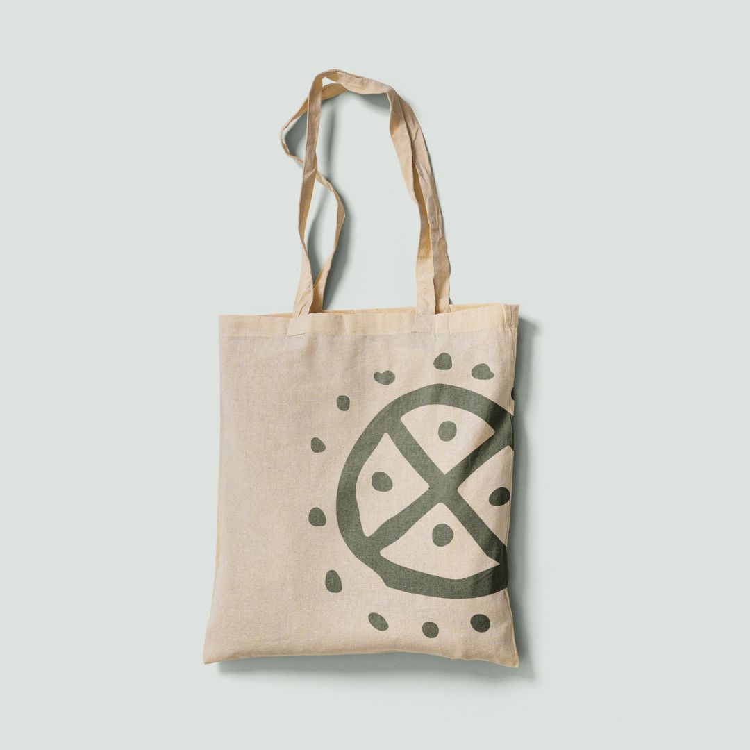 Tote bag in cotone naturale con il logo rituale di Solstizio Agency stampato a campo pieno, parte del progetto di brand design identità visiva.