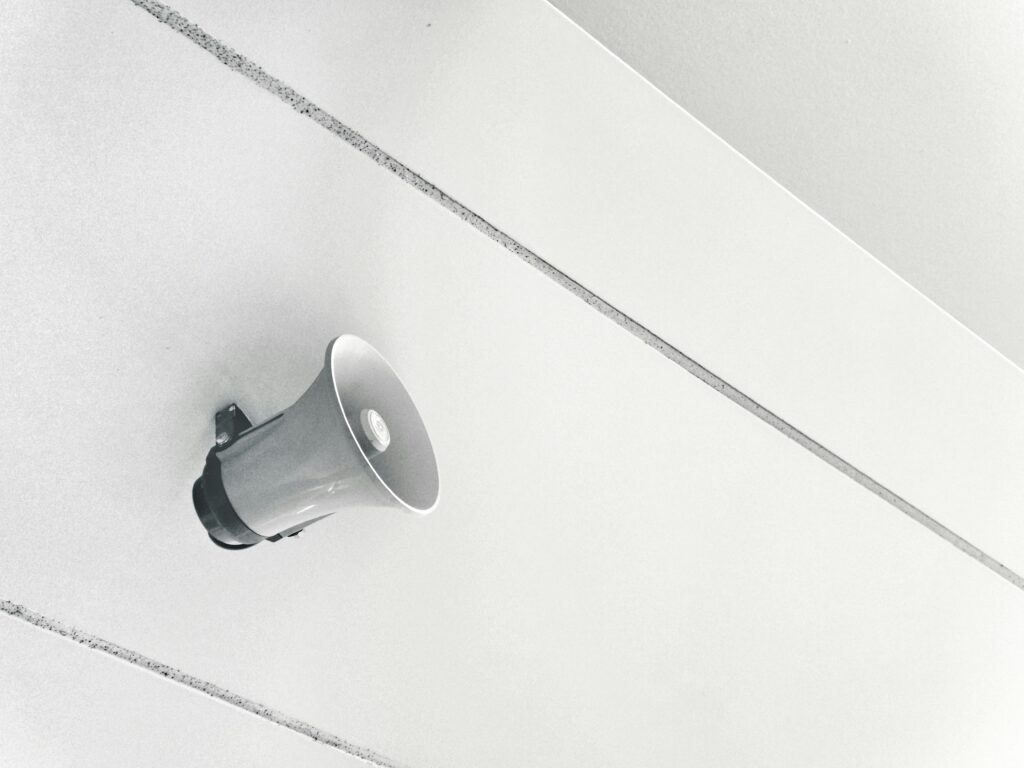Megafono montato su una parete bianca, rappresentazione del concetto di comunicazione del brand