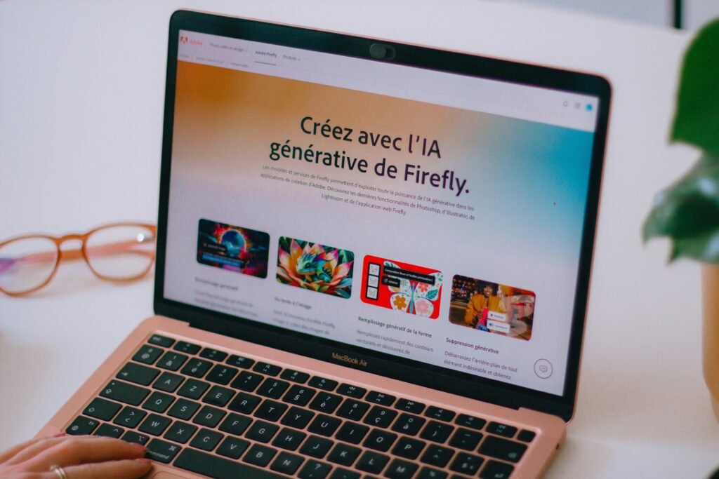 Laptop con la schermata di Adobe Firefly che mostra strumenti di intelligenza artificiale generativa per la grafica.