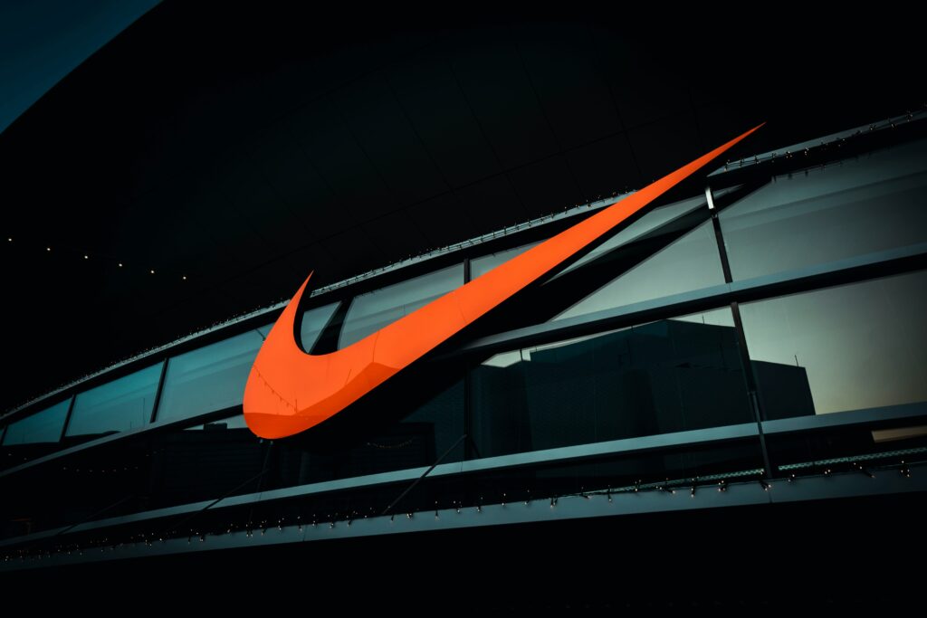 Insegna luminosa del logo Nike su un palazzo, esempio di brand identity forte e riconoscibile a livello globale.
