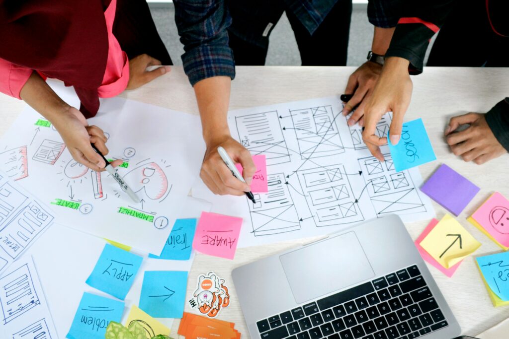 Due persone discutono un prototipo digitale mostrato su un laptop, esempio di collaborazione nel design centrato sull’utente